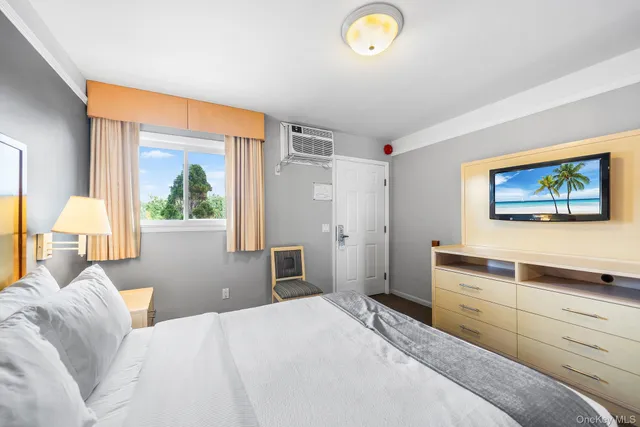 a bedroom with a bed and a painting on the wall