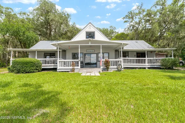 a view of a house with yard and tree s