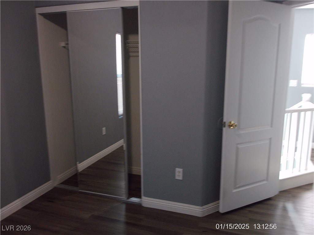 7332 Ribbon Ridge Avenue Las Vegas, NV 89129 - Photo 12 of 28 Unfurnished bedroom featuring multiple windows, dark wood-style flooring, and a closet