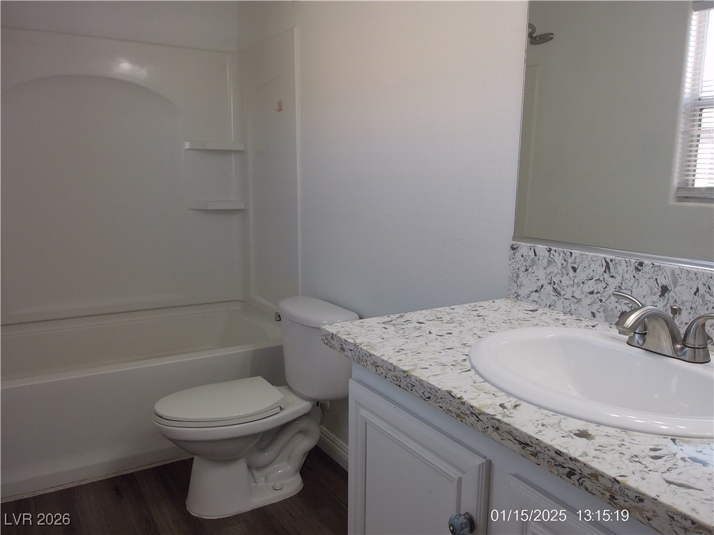 7332 Ribbon Ridge Avenue Las Vegas, NV 89129 - Photo 23 of 28 Bathroom with vanity, dark wood-style flooring, and washtub / shower combination
