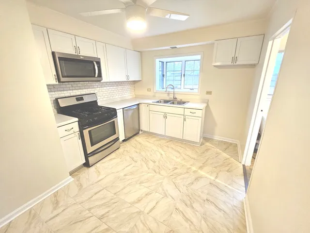a kitchen with granite countertop a refrigerator stove and sink