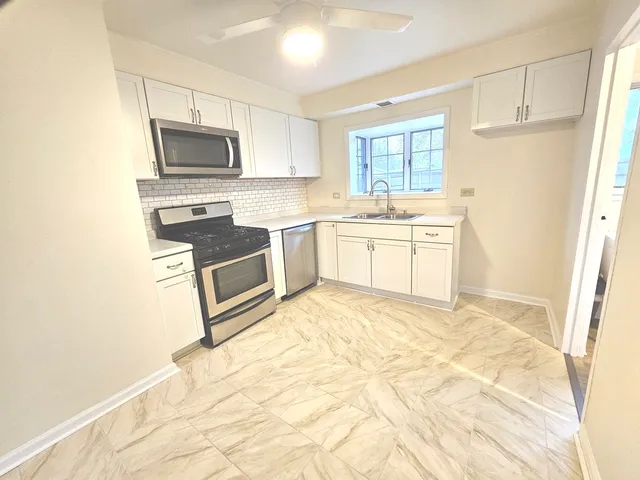 a kitchen with granite countertop a stove a sink and a microwave