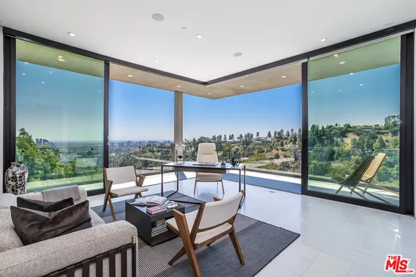 a living room with furniture and a floor to ceiling window