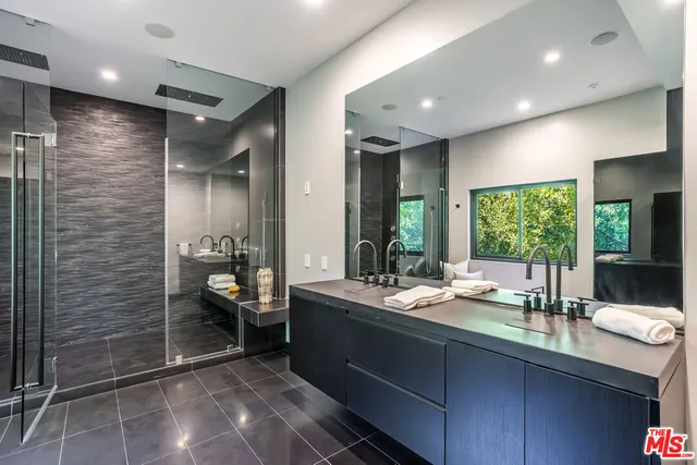 a bathroom with a double vanity sink and large mirror
