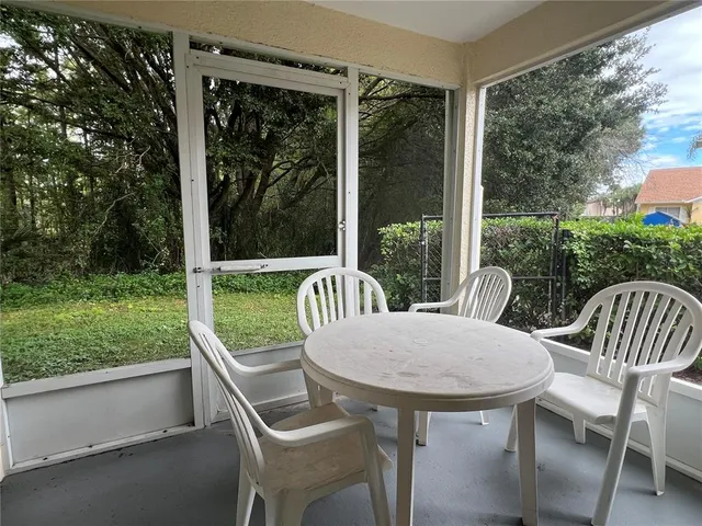 a view of a porch with a table chairs and a yard