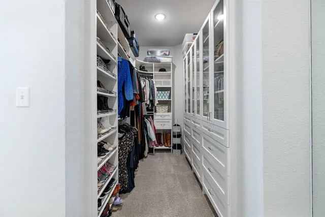 a view of walk in closet with clothes and shoes