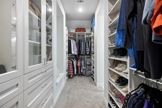 a view of walk in closet with clothes and shoes