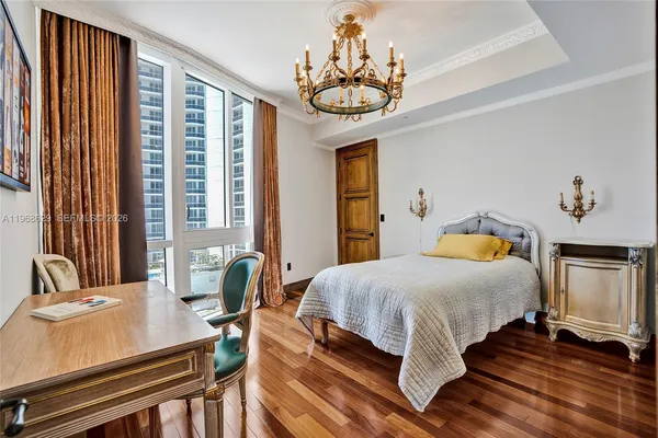 a bedroom with a bed and a chandelier