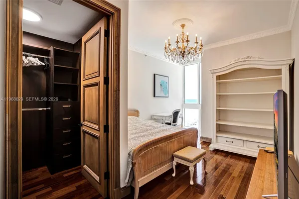 a bedroom with a bed and a chandelier