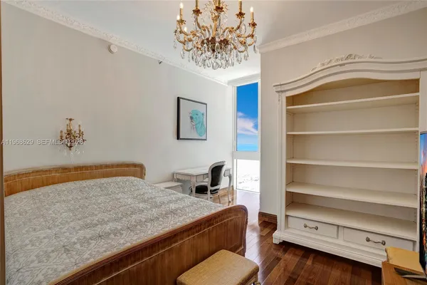 a bedroom with a bed and a chandelier