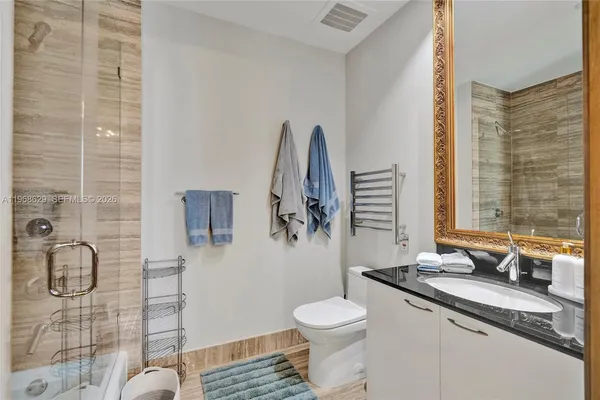 a bathroom with a granite countertop sink toilet and shower