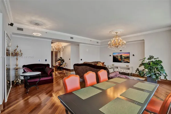 a living room with furniture a chandelier and a rug