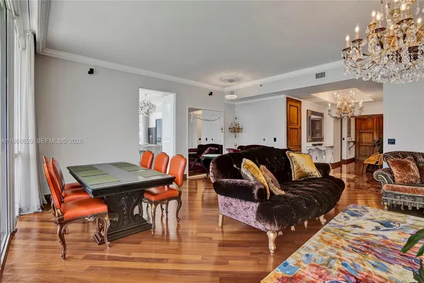 a living room with furniture a chandelier and a rug