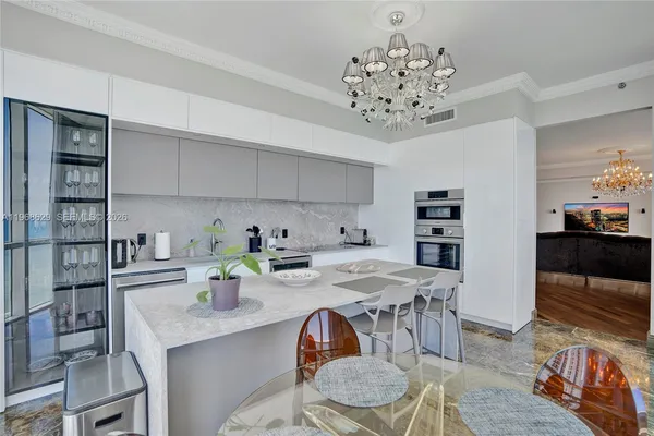 a kitchen with stainless steel appliances granite countertop a table chairs in it and wooden floor