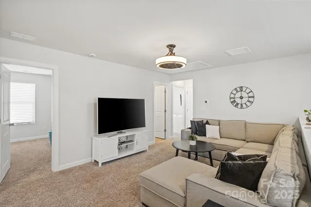a living room with furniture and a chandelier