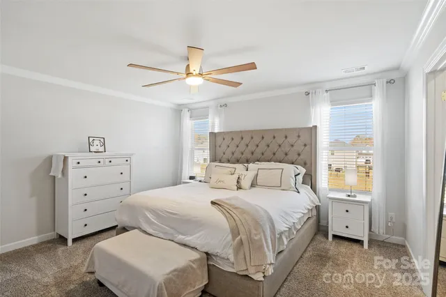 a bedroom with a large bed and a chandelier