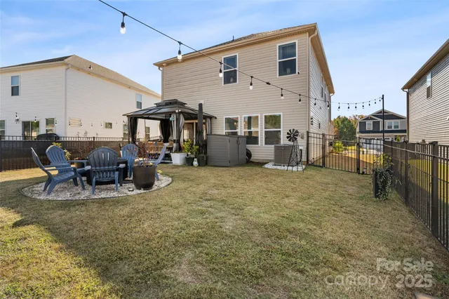 a view of a patio with couches table and chairs with wooden floor and fence