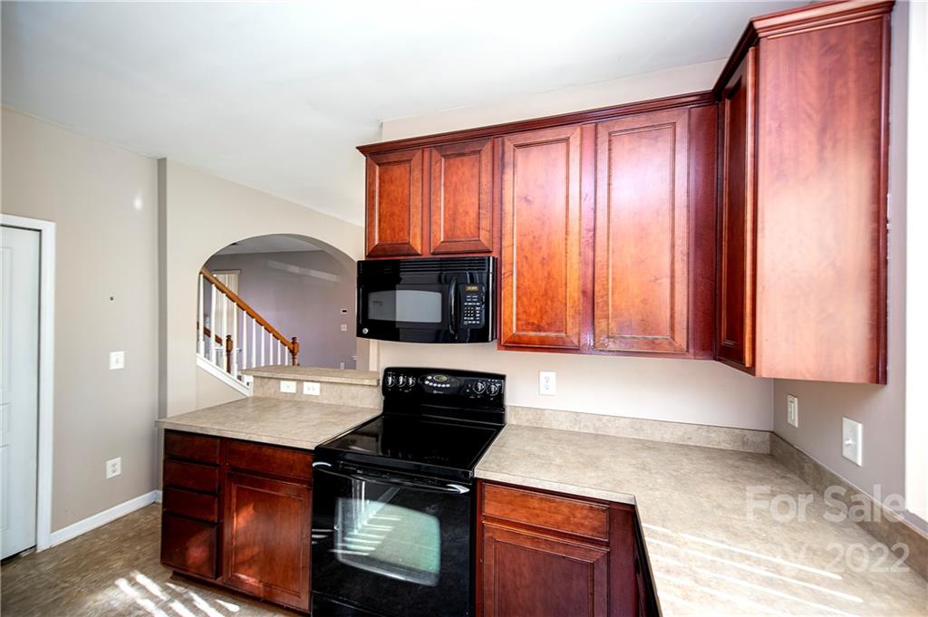 949 Copperstone Lane, Unit 203 Fort Mill, SC 29708 - Photo 6 of 19 a kitchen with granite countertop a stove top oven microwave and cabinets