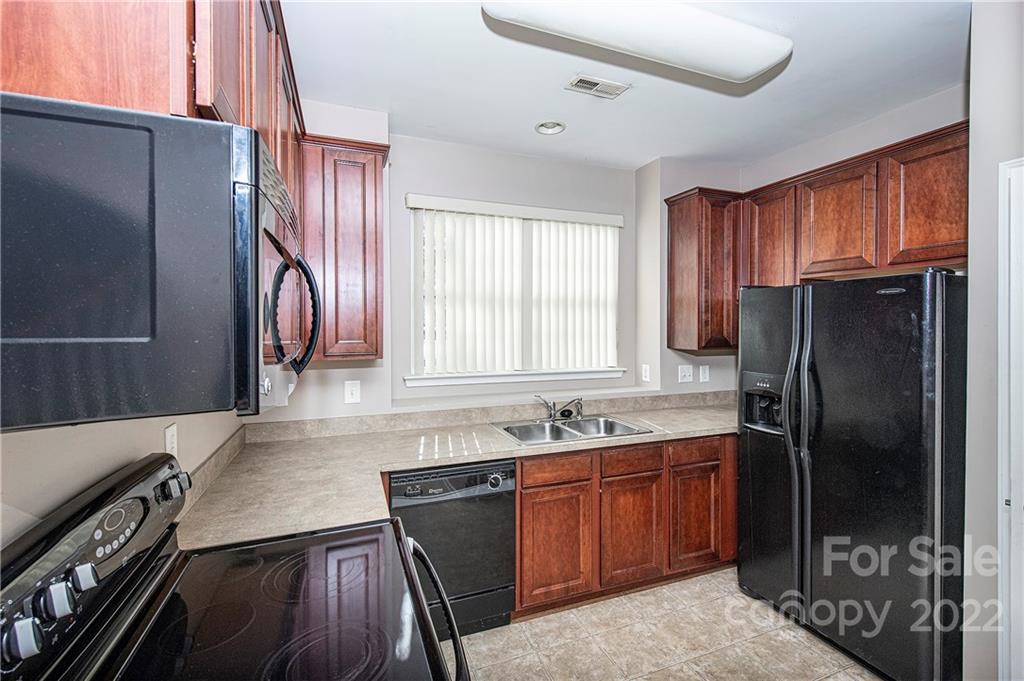 949 Copperstone Lane, Unit 203 Fort Mill, SC 29708 - Photo 7 of 19 a kitchen with stainless steel appliances granite countertop a refrigerator and a sink