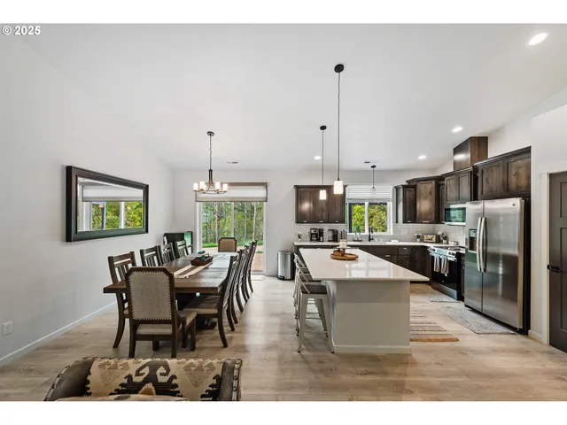 a dining room with furniture a kitchen view and a chandelier