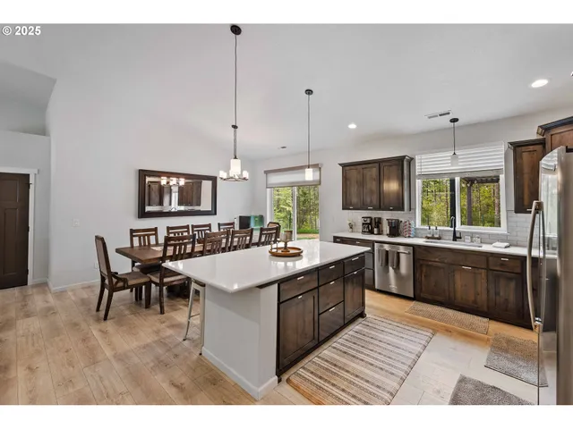 a large kitchen with kitchen island a sink table and chairs