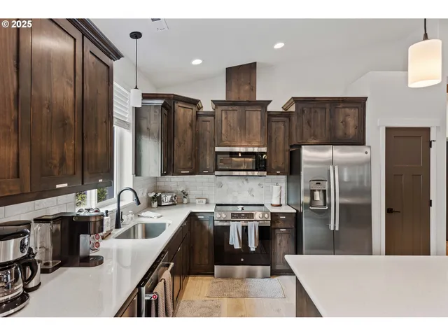 a kitchen with kitchen island granite countertop a sink refrigerator and microwave