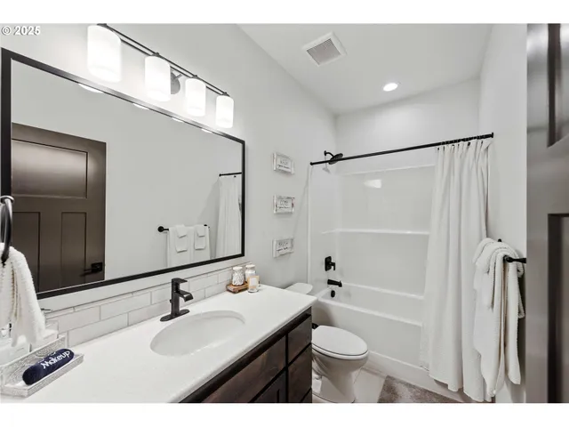 a bathroom with a sink toilet double vanity and shower