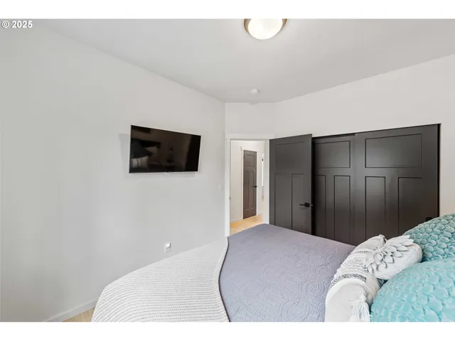 a bedroom with a bed and a flat screen tv