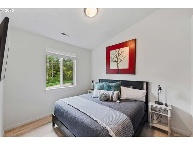 a bedroom with a bed and a painting on the wall