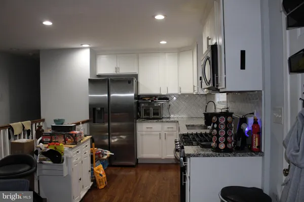 a kitchen with granite countertop white cabinets and a sink