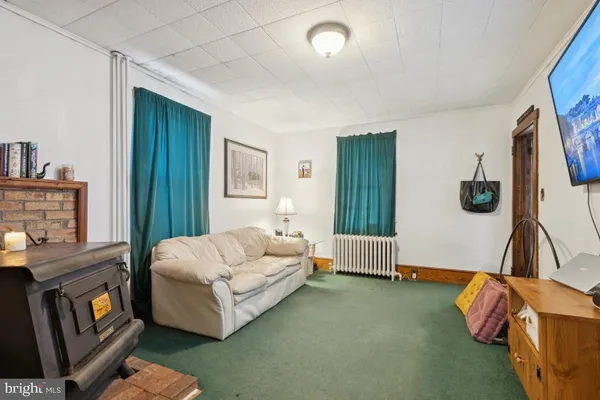 a bedroom with a bed and dresser with wooden floor