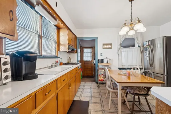 a kitchen with stainless steel appliances granite countertop a stove top oven a sink dishwasher a dining table and chairs with wooden floor