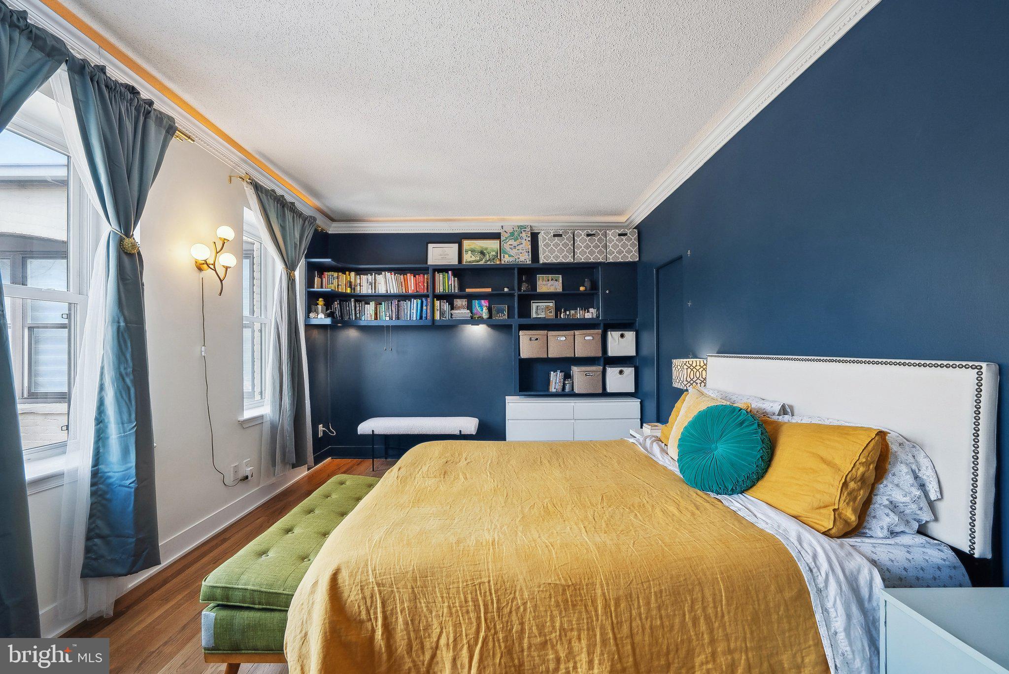 2630 Adams Mill Road Northwest, Unit 303 Washington, DC 20009 - Photo 13 of 18 a bedroom with a bed and a book shelf