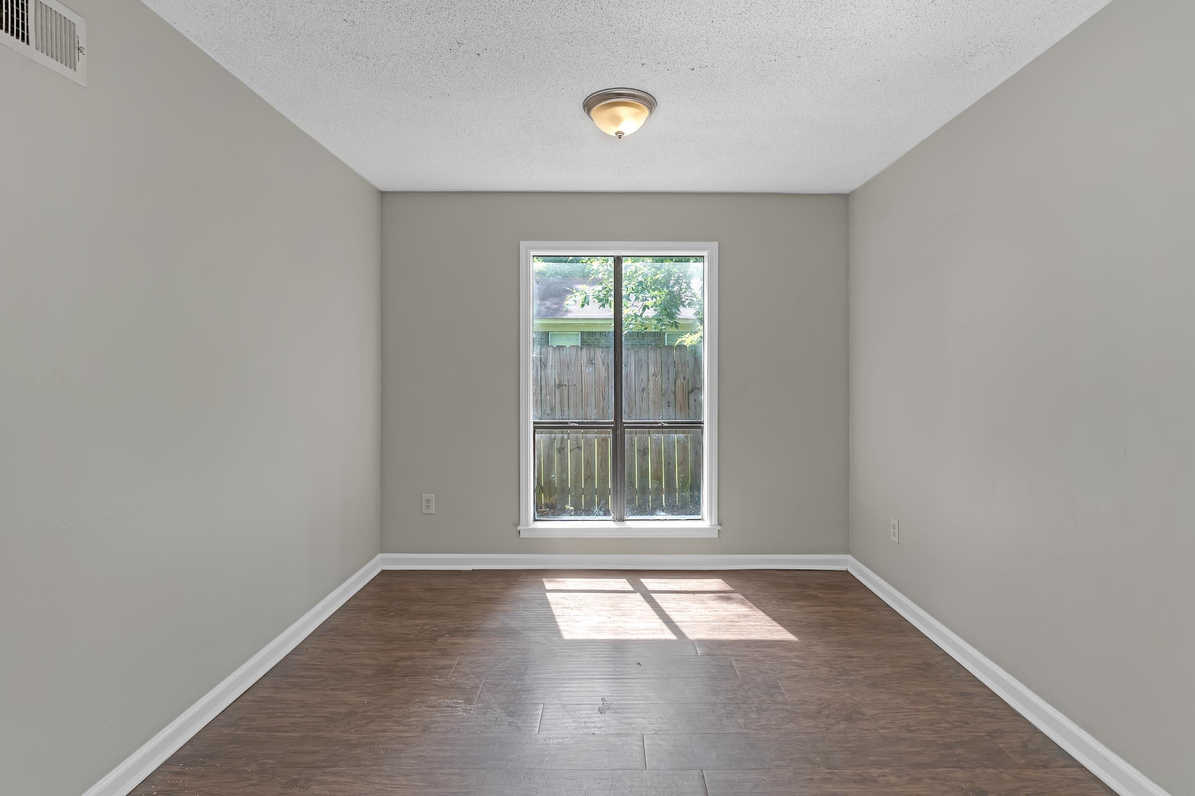 6128 Raintree Drive Memphis, TN 38115 - Photo 7 of 30 Empty room with dark wood-type flooring and a textured ceiling