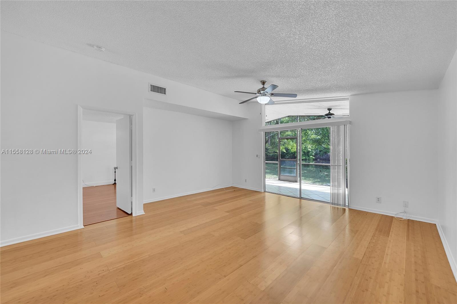 616 Woodgate Circle, Unit D Sunrise, FL 33326 - Photo 4 of 15 a view of an empty room with wooden floor and a window