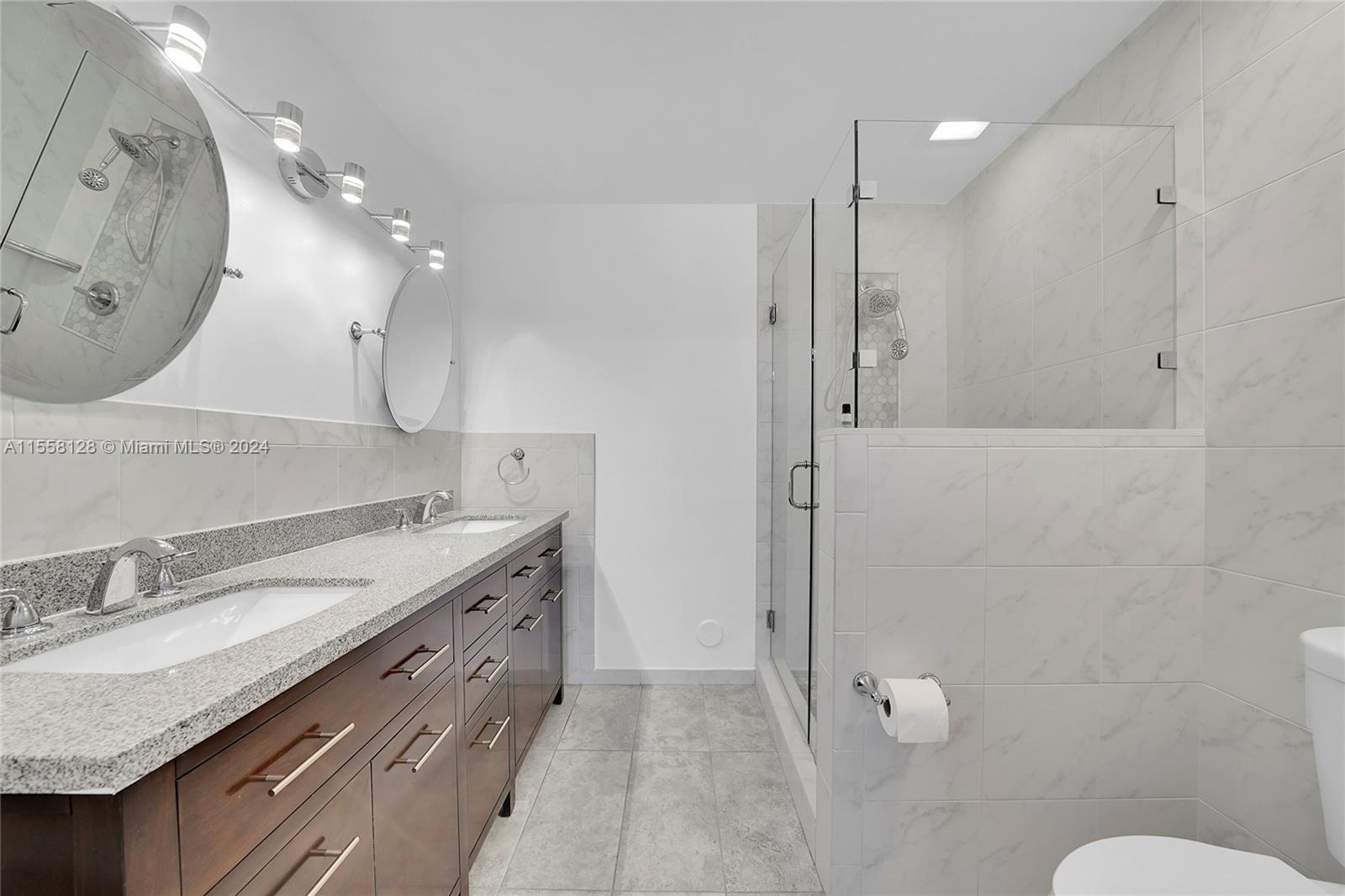 616 Woodgate Circle, Unit D Sunrise, FL 33326 - Photo 5 of 15 a spacious bathroom with a granite countertop sink a toilet and a mirror