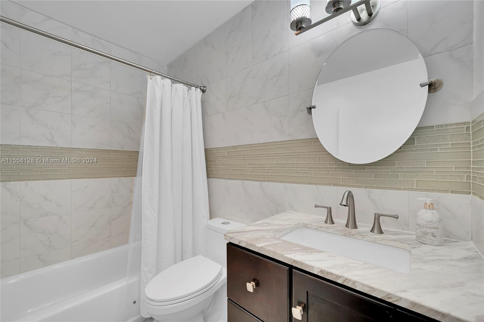 616 Woodgate Circle, Unit D Sunrise, FL 33326 - Photo 9 of 15 a bathroom with a granite countertop sink a toilet and shower