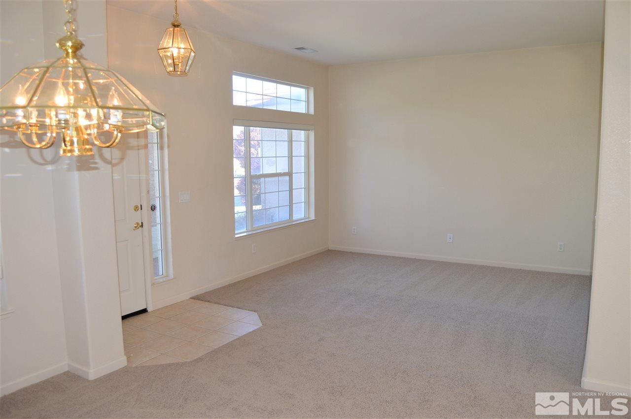 1170 Broadview Court Reno, NV 89521 - Photo 10 of 25 an empty room with a chandelier fan and a window