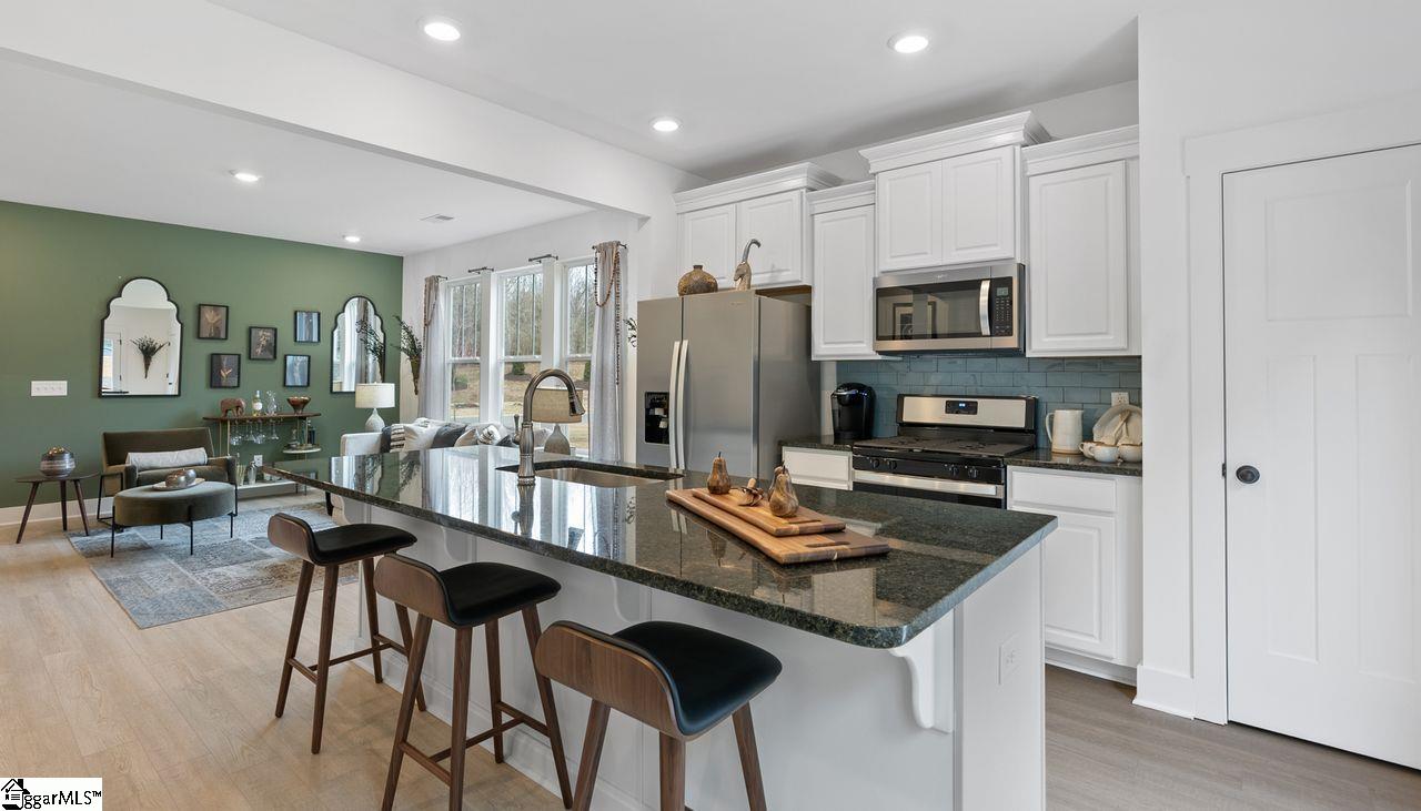 Upgraded white cabinets and stainless gas appliances in the kitchen. *Model Home-For illustrative purposes only*
