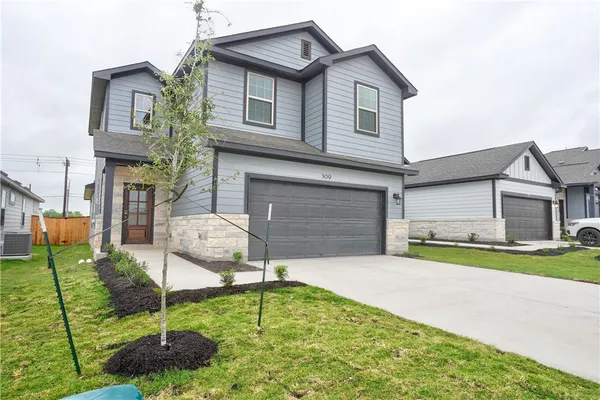 a front view of a house with a yard and garage