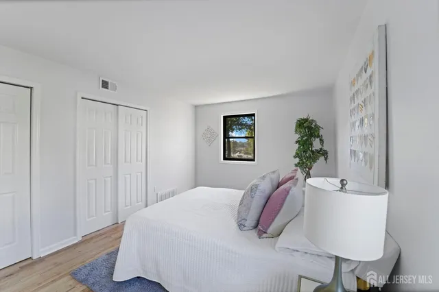 a bedroom with a white bed and a chair