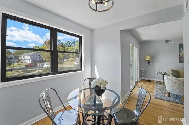 a view of a dining room with furniture a chandelier and wooden floor