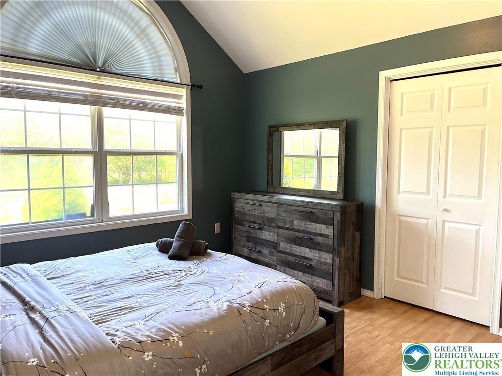 1646 Clover Road Long Pond, PA 18334 - Photo 9 of 24 Vaulted ceilings and a large arched window enhance this comfortable bedroom with wood floors.