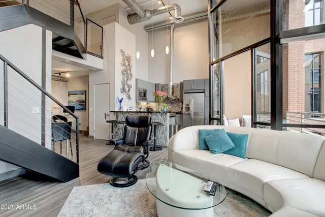 a living room with furniture a rug and a large window