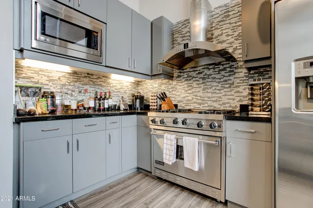 a kitchen with stainless steel appliances granite countertop white cabinets and a stove