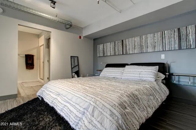 a bedroom with a bed and wooden floor