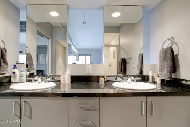 a bathroom with double sink and a mirror