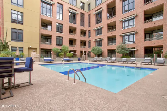 a view of a building with a swimming pool and sitting area