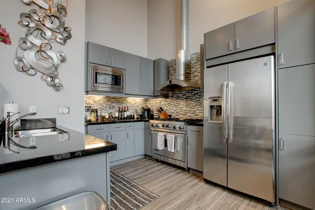 a kitchen with stainless steel appliances granite countertop a sink stove and refrigerator