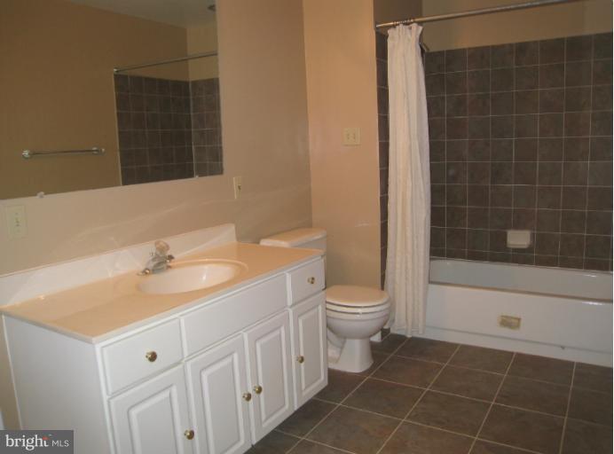 10118 Colvin Run Road Great Falls, VA 22066 - Photo 25 of 26 a bathroom with a granite countertop sink toilet and shower